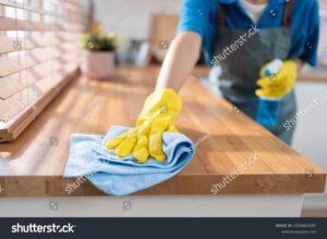 A professional cleaner wiping down kitchen surfaces in an empty, freshly painted home. Commercial Cleaning